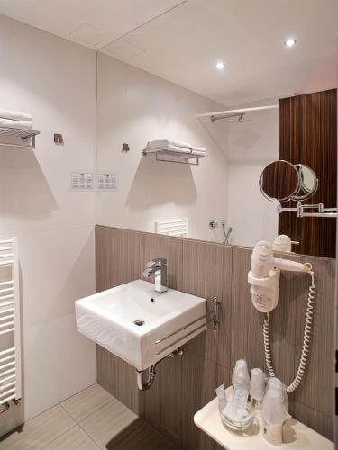 a bathroom with a white sink and a mirror at Hotel PurPur in Prague