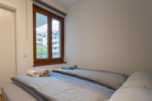 two beds sitting in a room with a window at Spacious with balcony in Vienna