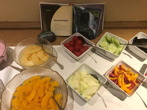 Una mesa cubierta con cuencos de frutas y verduras en Pension und Ferienwohnung Schütte, en Schmallenberg