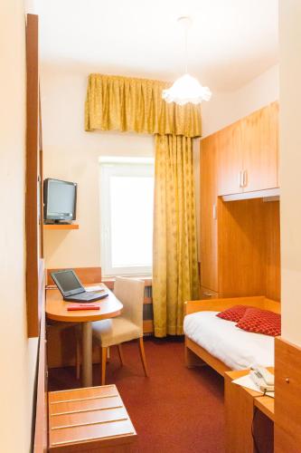 a hotel room with a bed and a desk with a laptop at Hotel Sant'Ilario in Rovereto