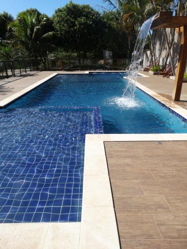 a swimming pool with a fountain in the middle at Pousada Voo das Garças in Bonito