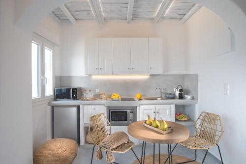 a kitchen with a table and chairs in a kitchen at Perla Suites - Delmar Collection in Pollonia