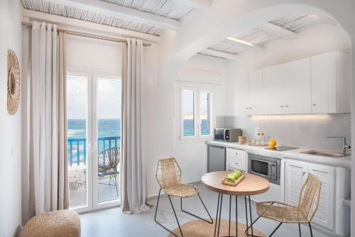 une cuisine avec une table et des chaises et l'océan dans l'établissement Perla Suites, à Pollonia