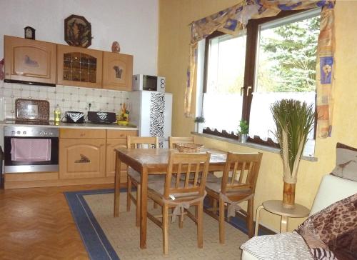 a kitchen with a table and chairs in a room at Ferienwohnung direkt in Ilmenau in Ilmenau
