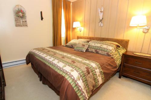 a hotel room with a bed and a night stand at Beautifully decorated, 3 bedroom 2 bedroom condo is moments away from the Base Lodges Whiffletree D2 in Killington