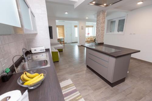 a kitchen with a sink and a bowl of bananas on a counter at Casa Avenida del Agujero in Gáldar