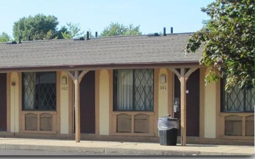 a building with a trash can in front of it at Kensington Inn - Howell in Howell