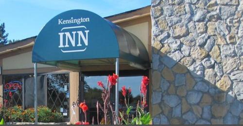 a sign for an inn in front of a building at Kensington Inn - Howell in Howell