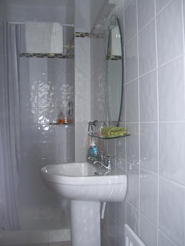 a white bathroom with a sink and a mirror at Meadowfield in Ballyvaughan