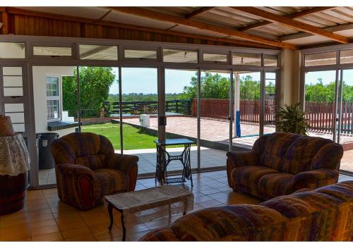 a screened in porch with two chairs and a table at Sundaze Riverside House - Colchester - 5km from Elephant Park in Colchester