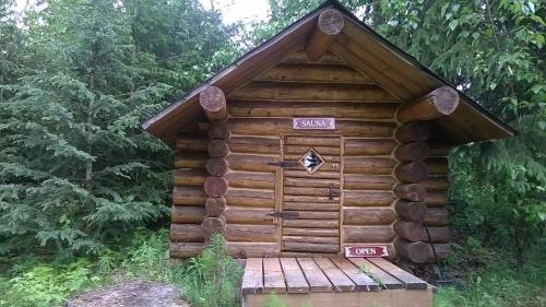 a log cabin with signs on the side of it at Hope Alaska's Bear Creek Lodge in Hope