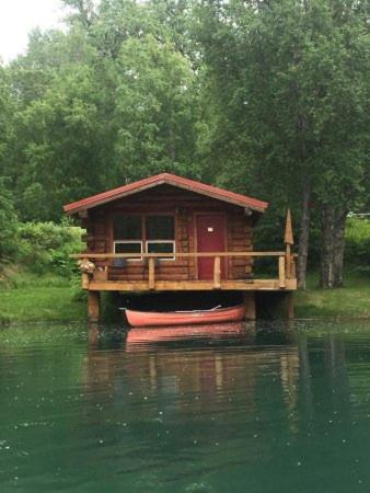 a small house on a boat in the water at Hope Alaska's Bear Creek Lodge in Hope
