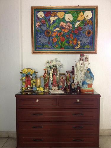 a wooden dresser with a painting on the wall at Hotel Casa Pablo in Neiva