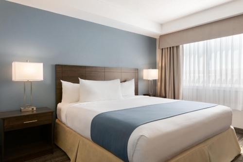 a large bed in a hotel room with two lamps at Travelodge Suites by Wyndham New Glasgow in New Glasgow