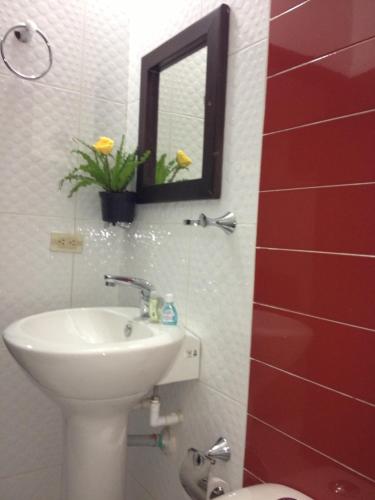 a bathroom with a sink and a mirror at Hotel Casa Pablo in Neiva