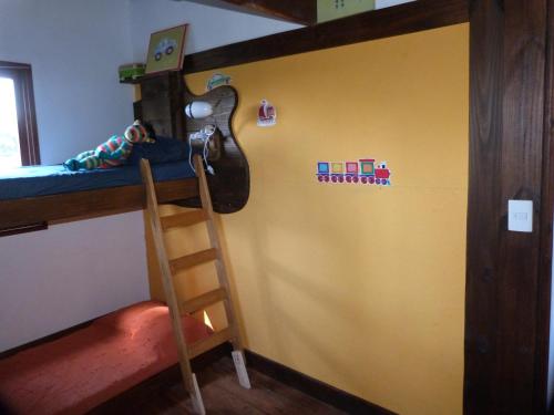 a room with a bunk bed with a guitar on the wall at Cabaña en la playa. ventanales y terraza al mar in Salinas 