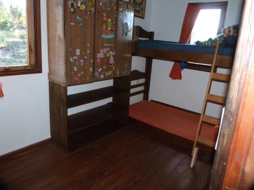 a room with a bunk bed and a ladder at Cabaña en la playa. ventanales y terraza al mar in Salinas 