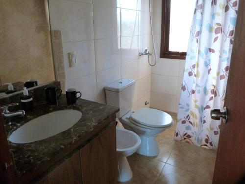 a bathroom with a sink and a toilet and a window at Cabaña en la playa. ventanales y terraza al mar in Salinas 