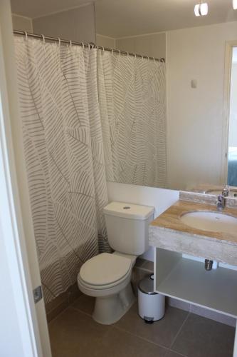 a bathroom with a toilet and a sink at Resort Laguna Bahía, Océano Piso 12 Algarrobo in Algarrobo