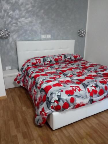1 dormitorio con 1 cama con colcha roja y blanca en Mary BeB, en Le Torri