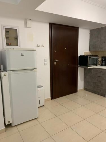 a kitchen with a refrigerator and a microwave at Jacuzzi studio close to athens airport!! in Pallíni
