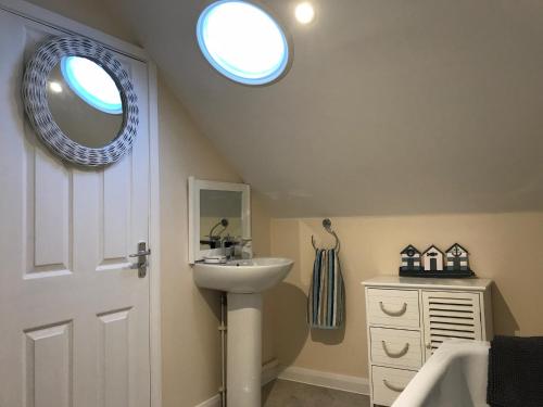 a bathroom with a sink and a mirror at Windmill Cottage in Worthing