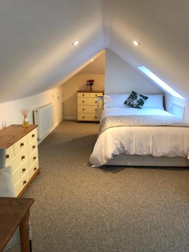 a bedroom with a bed and a dresser in a attic at Windmill Cottage in Worthing