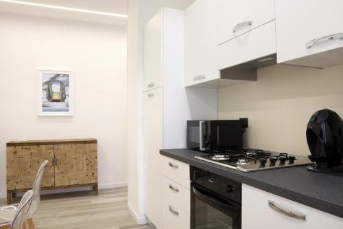 a kitchen with white cabinets and a stove top oven at Primo a destra in Campobasso