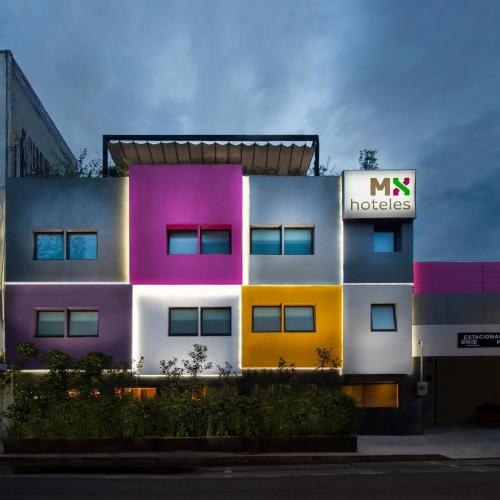a multicolored building with a nx hotels sign on it at Hotel MX más roma in Mexico City