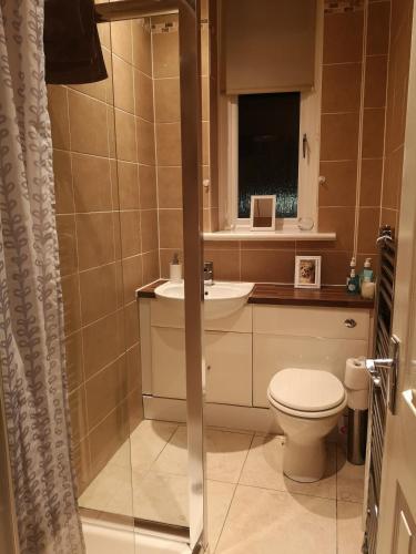 a bathroom with a toilet and a sink at Sleep Well Apartment in Glasgow