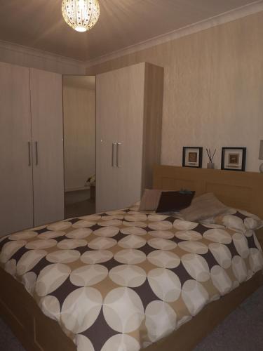 a bedroom with a large bed with a black and white comforter at Sleep Well Apartment in Glasgow