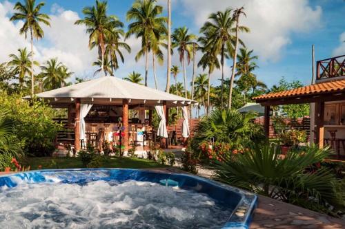 a pool in the yard of a resort with palm trees at 21 Palms in Las Galeras