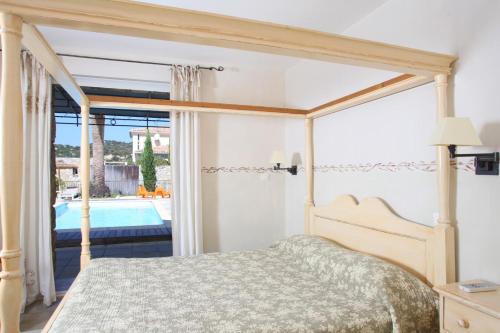 a bedroom with a bed and a view of a pool at Clos des Oliviers in Lumio