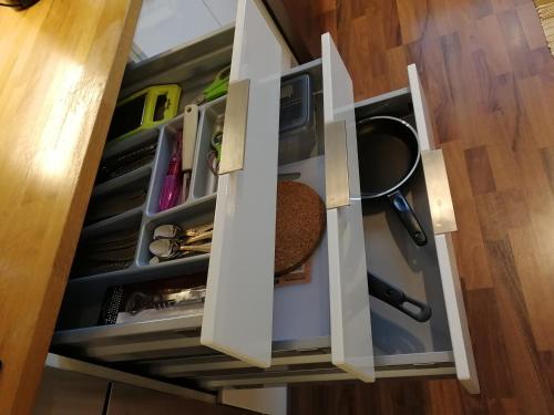 a cupboard filled with lots ofartmentsitures at Sun Apart Vuorenrinne in Kotka