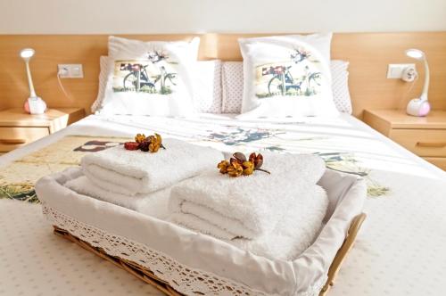 Una cama con toallas blancas y flores. en Apartamento "El Lilà 2" - Parking incluido, en Girona