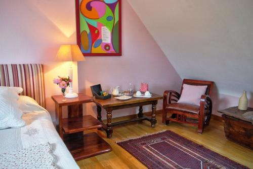 1 dormitorio con 1 cama, 1 mesa y 1 silla en Chambre d'Hôtes Entre Mer et Monts, en Plomodiern