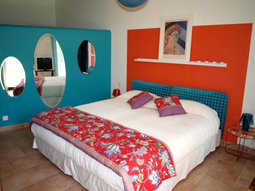 a bedroom with a bed with red and blue walls at Le relais d'Angélique in Lunel