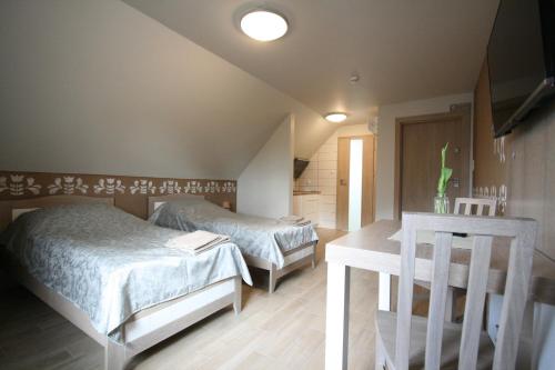 a bedroom with two beds and a table at Noclegi Cameleon in Słupca