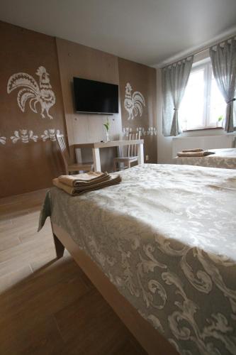 a bedroom with a large bed with a tv on the wall at Noclegi Cameleon in Słupca