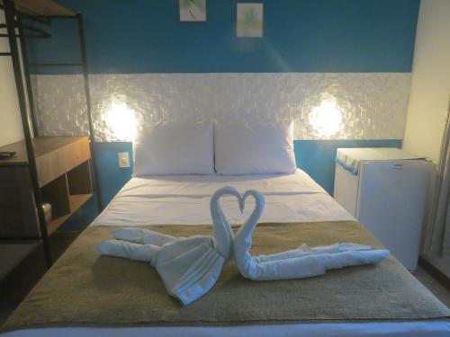 two towels in the shape of a heart on a bed at Pousada Guapuruvu in Abraão