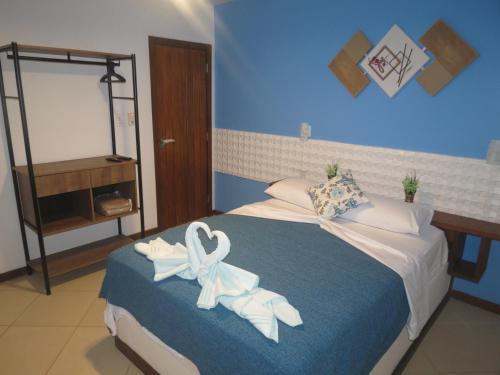 a bedroom with a bed with white towels on it at Pousada Guapuruvu in Abraão