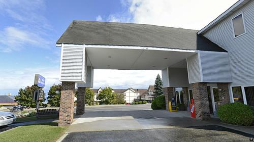 a building with a gas station with a car at Americas Best Value Inn Saint Ignace in Saint Ignace