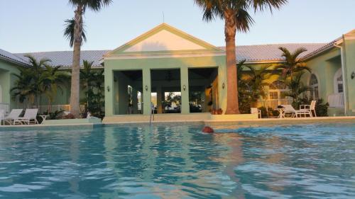 a swimming pool in front of a house at Townhouse by The Bay, Little Bay Country Club ,Negril in Orange Bay