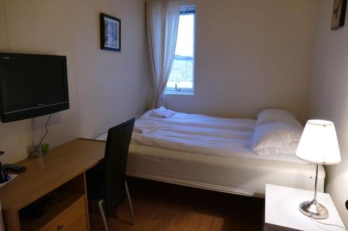 ein kleines Schlafzimmer mit einem Bett und einem Fenster in der Unterkunft Litlabjarg Guesthouse in Hrafnabjorg