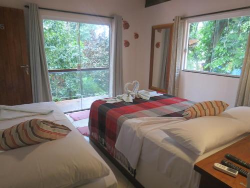 a bedroom with two beds and a window at Pousada Guapuruvu in Abraão