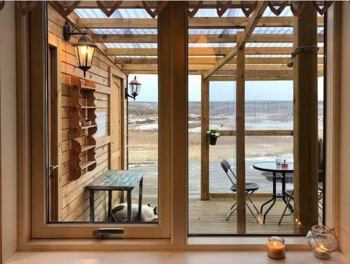 a screened in porch with a view of the ocean at Litlabjarg Guesthouse in Hrafnabjorg