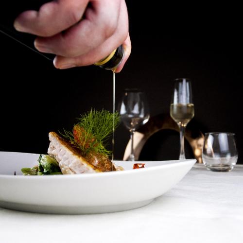 a person is holding a piece of food on a plate at Hotel Masaniello Luxury in Casoria