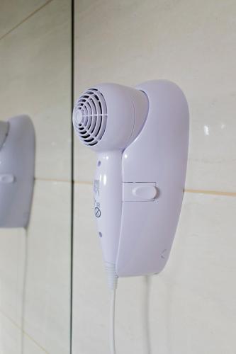 a white hair dryer in a bathroom stall at Hotel Hohenau in Hohenau