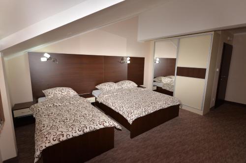 a hotel room with two beds and a mirror at Apartmani 401- Bijeljina in Bijeljina