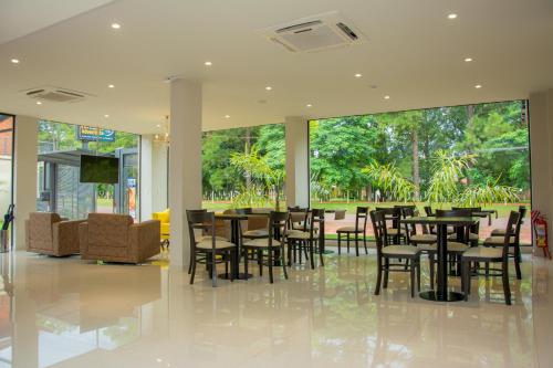 a restaurant with tables and chairs and a large window at Hotel Hohenau in Hohenau